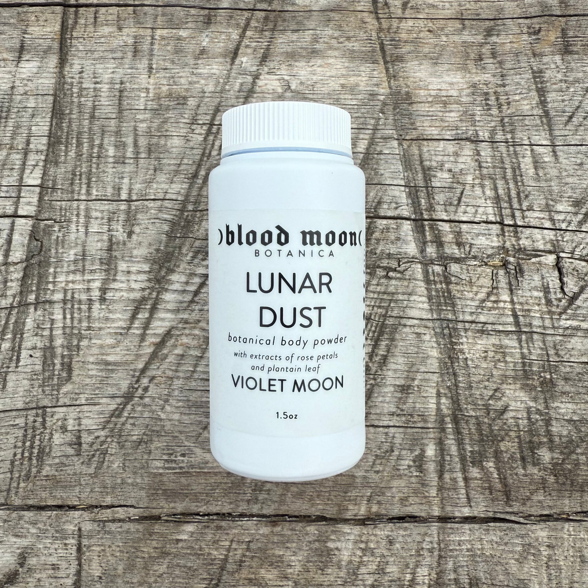 Bottle of 'Lunar Dust' from Violet Moon on a wooden surface
